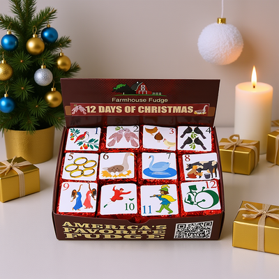 Box of Farmhouse Fudge's '12 Days of Christmas' fudge with decorative Christmas tree and gifts in the background.